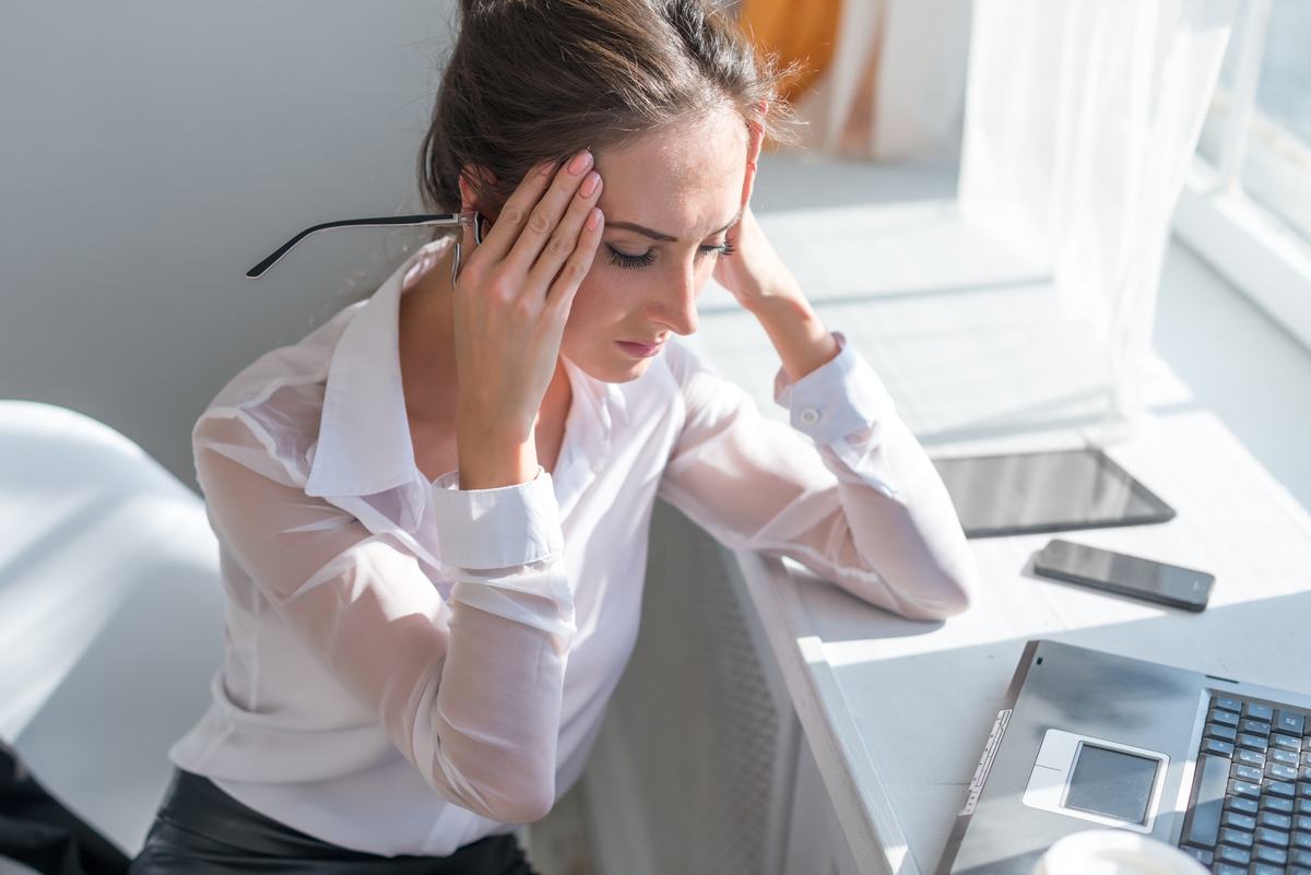 depressed tired young business woman suffering from depression in office