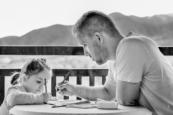 father and daughter at table doing homework